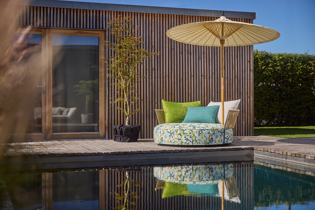 Isola Lounge-Insel mit Kissen und Schirm am Pool